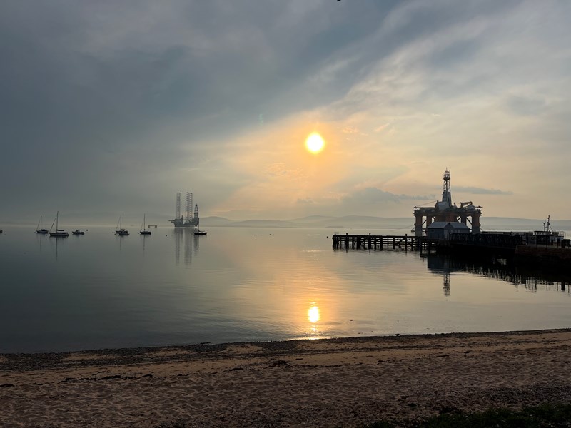 photo of a sunset looking over Cromarty harbour and an oil ref