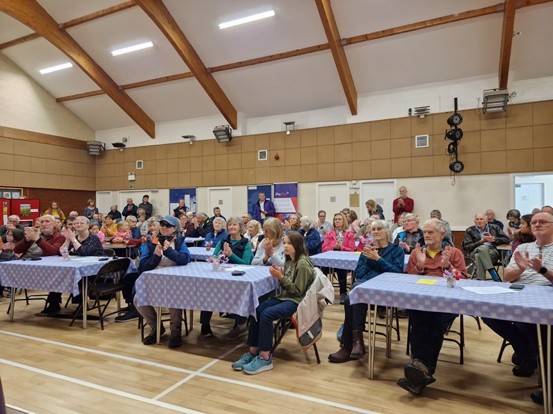 audience sitting at tables applauding a prizewinner