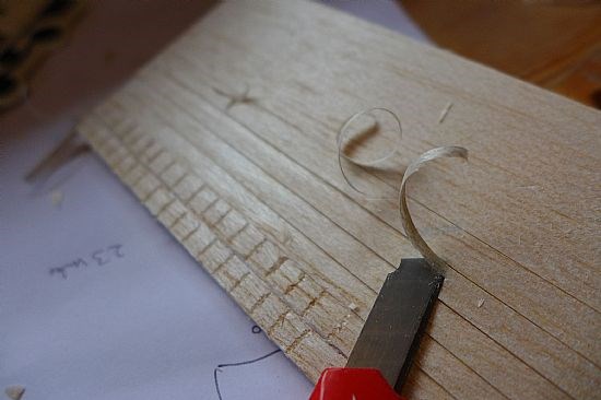 Scribing in balsa wood the effect of a timber shingle roof.