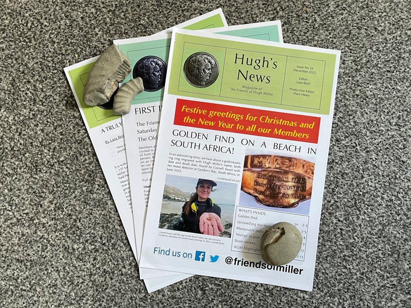 Printed copies of Hugh's News, charity newsletter, with fossil ammonites surrounding it