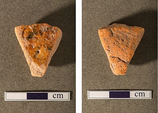 Piece of glazed medieval pottery with stamped star shaped decoration