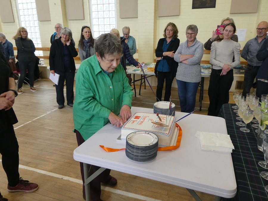 Long standing member Margaret Cowie cuts the cake