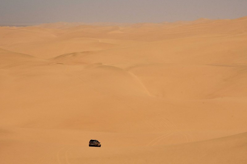 Distant jeep in a desert landscaoe