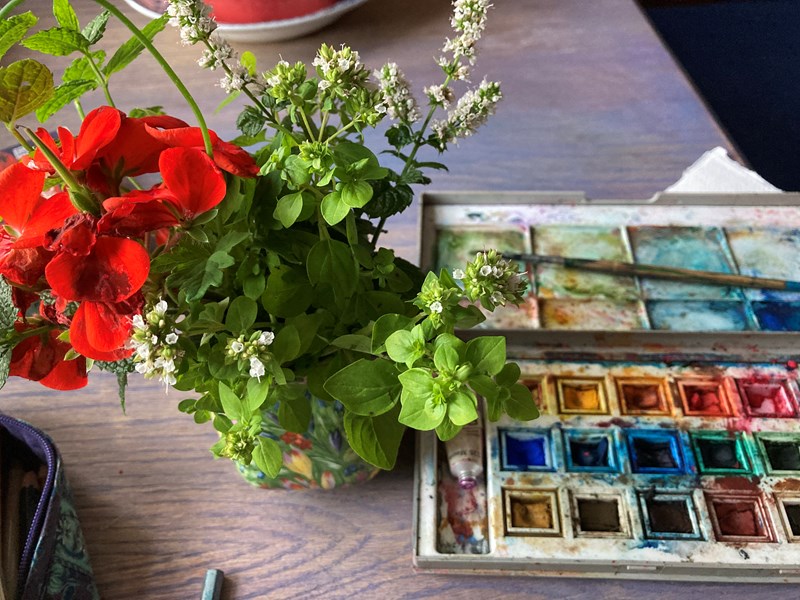 Photo of small bunch of flowers and a set of watercolours