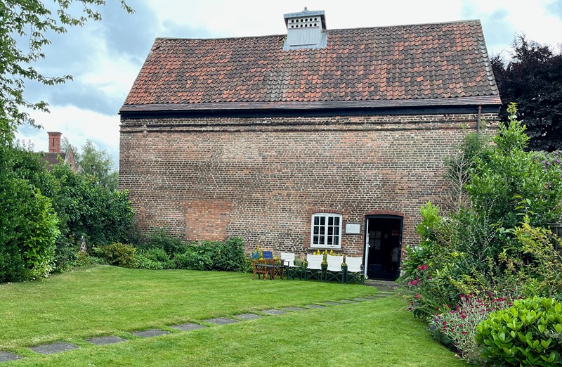 A red brick building from the exterior showing the glover or opening on the roof where the doves would have entered