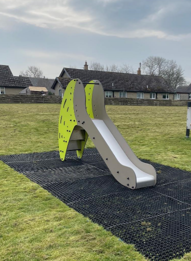 A slide in green and black on a playing field