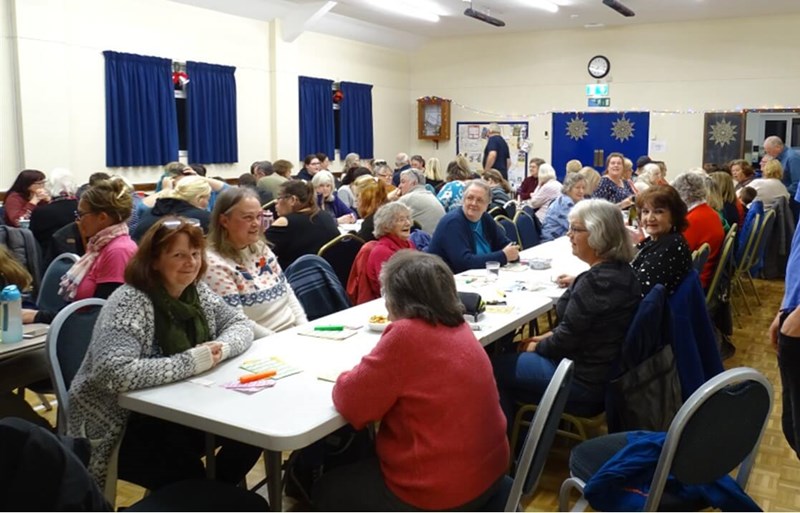 Lots of people sitting at tables playing bingo