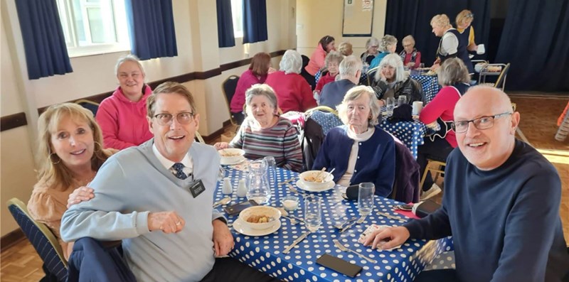 People sitting eating lunch and looking at the camera