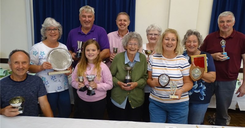 Winners of the horticultural show holding their cups and trophies