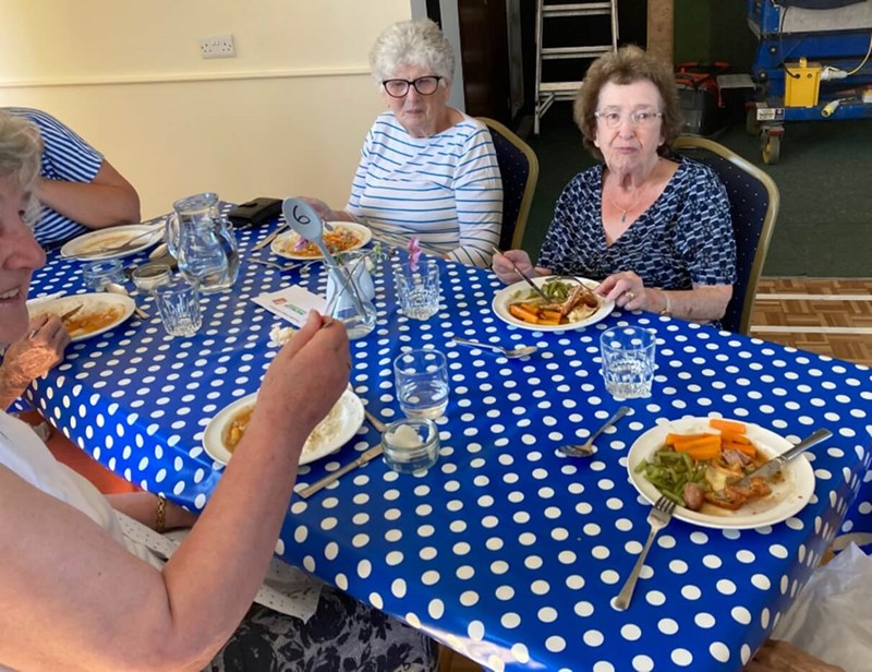 People sitting round table eating dinner