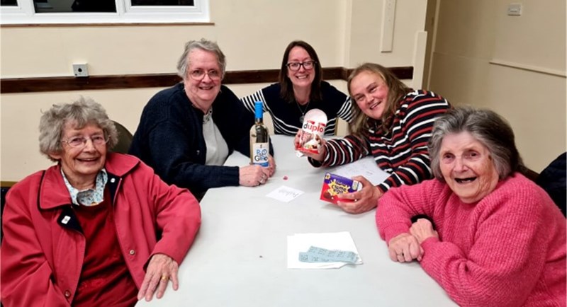 People sitting at table smiling at the camera