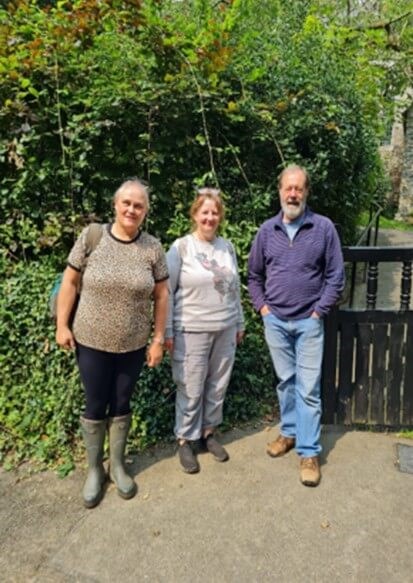 Three people standing and lookiing at the camera