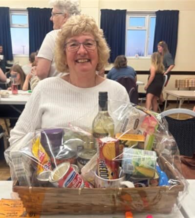 Person smiling at camera in front of bingo prize