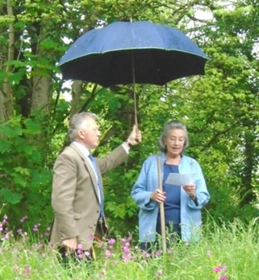Two people outside under an umberella