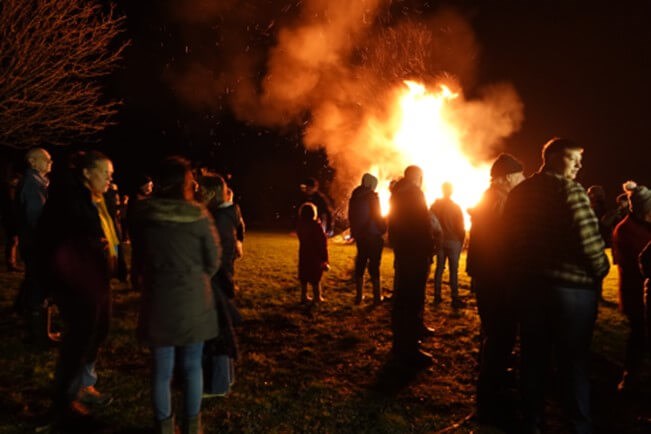 People standing in front of the bonfire