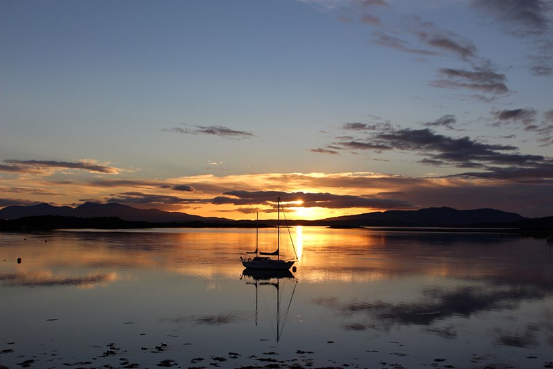 View from Connel across to Mull highlighting a yacht in the sunsetaght