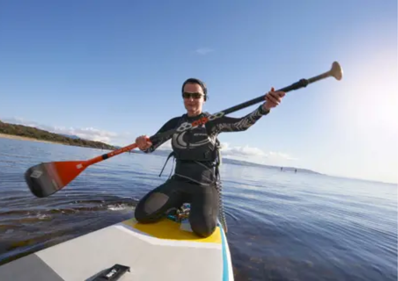 lady kayaking on the sea, blue skies