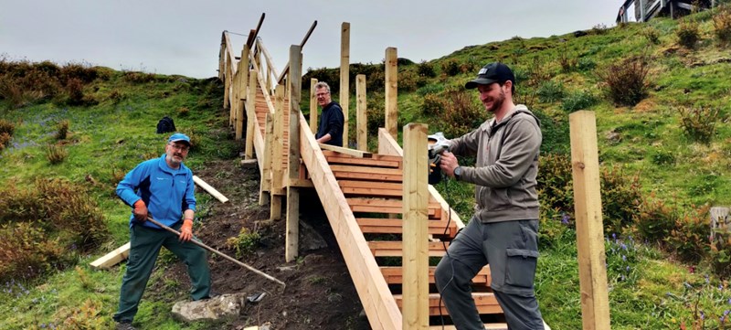 People building wooden steps, in the open air